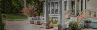 A light blue home with a front deck and seating.