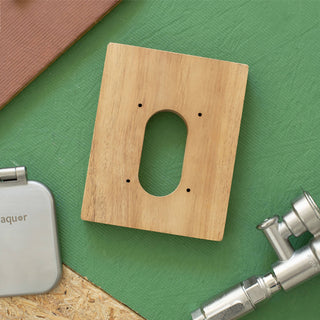 The teak mounting block v2+ shown laying on a piece of sheathing next to the house hydrant v2+ and brushed stainless v2+ debris cover.