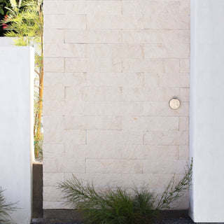 A brushed stainless v1+ debris cover shown on masonry siding.