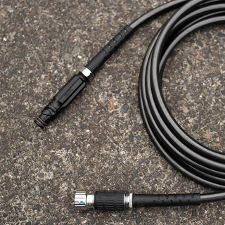 A black hose adapter sits disconnected on concrete.
