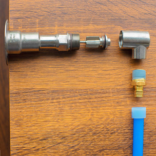 A product shot showcasing the correct order to attach an Aquor inlet. In order from left to right, the Aquor Hydrant, operating rod, half inch NPT elbow inlet, PEX adapter, PEX piping.
