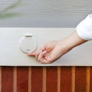 A hand about to open the cover of a matte white v1+ debris cover.