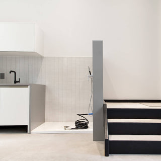 The universal hydrant installed in an indoor dog washing station with a hose and connector.