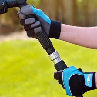 Two hands connecting the hose adapter to attach a spray nozzle.
