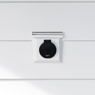 A matte black v1+ debris cover shown on white lap siding.
