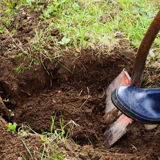 Person digging a hole to prepare for ground hydrant installation.