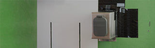 A stainless steel mounting box V2+ with a house hydrant v2+ installed onto sheathing, weatherproofed with zip system flashing. A board is held up to display what siding might look like.