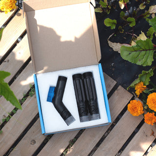 One removable faucet hose connector and two straight hose connectors in a blue box placed in a garden. 