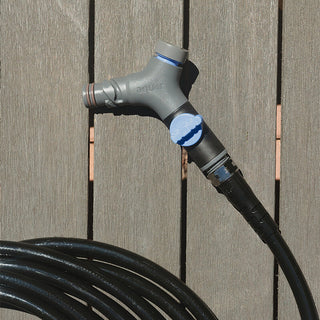 A slate gray comfort grip vb hose connector and hose laying on a porch