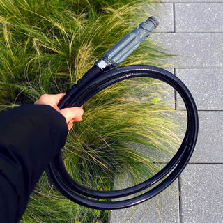 Hand holding a slate gray straight hose connector and hose.