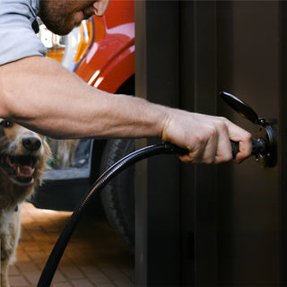A hand inserting a connector and hose into the matte black house hydrant V1+.
