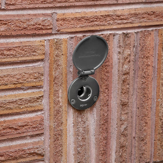 A front view of the Polymer Slate Gray House Hydrant V1+ on brick siding with the cover open.