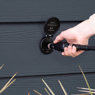 A hand connecting a jet black wide grip vb hose connector to a matte black house hydrant v1+.