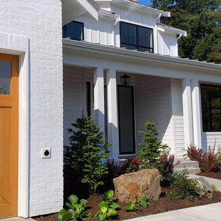 A white brick home with the matte black house hydrant V1+ installed.