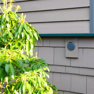 The Slate Gray House Hydrant V1+ on shingle siding with the cover closed.