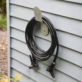 Aquor Ultralight Garden Hose, Utility Spray Nozzle, and Comfort Grip Hose Connector hanging on Stainless Steel Hose Hanger