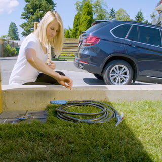 Homeowner getting ready to pick up the hose and connector by the ground hydrant.