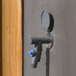 A slate gray vacuum breaker hose connector plugged into a slate gray house hydrant v1+ installed on concrete.