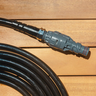 A slate gray wide grip vb hose connector and hose laying on a porch.