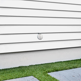 A brushed stainless  v1+ debris cover shown on white lap siding.