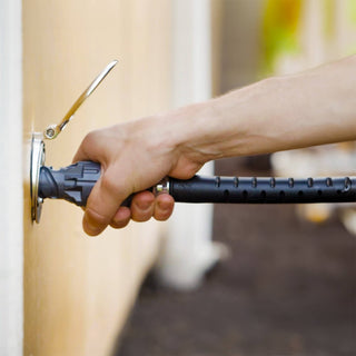 A hand inserting a wide grip vb hose connector into the brushed stainless house hydrant v1+.