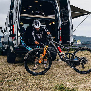 Man using RV City Water Inlet installed in a van to washdown his bike. 