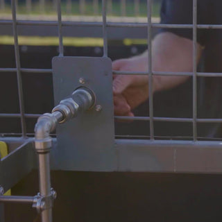 Man connecting to a rv city water inlet with a straight hose connector.
