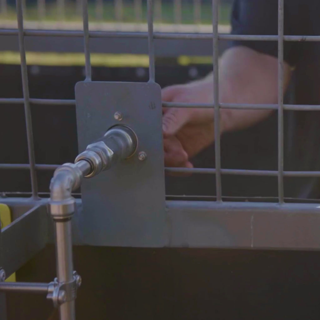 Man connecting to a rv city water inlet with a straight hose connector.